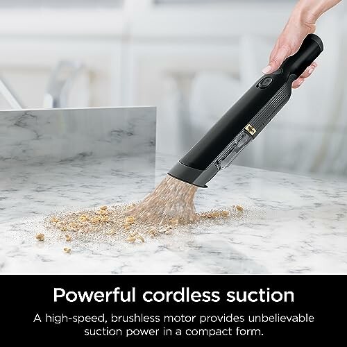 Cordless vacuum cleaner removing debris from a marble surface.