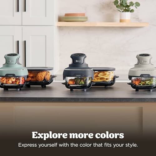 Three food processors in different colors on a kitchen counter with food inside.