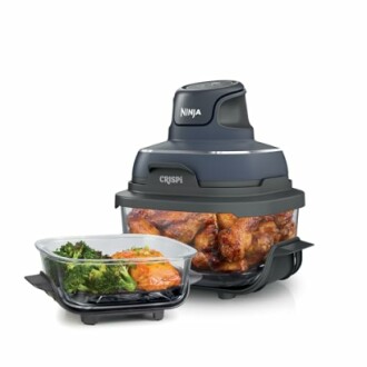 Ninja air fryer with cooked chicken and vegetables.